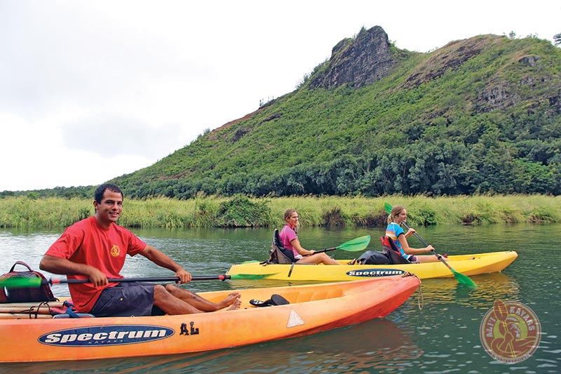 gallery-kauai-kayak-tours a group of people riding on the back of a boat in the water
