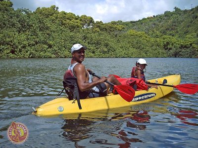 a man riding on the back of a boat in Wailua River
